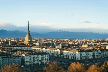 Vista panoramica di Torino con la Mole Antonelliana, Piazza Vittorio Veneto e le Alpi sullo sfondo.